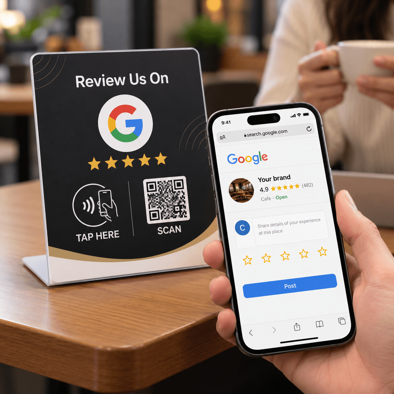 An acrylic review table stand next to a phone showing a Google review page